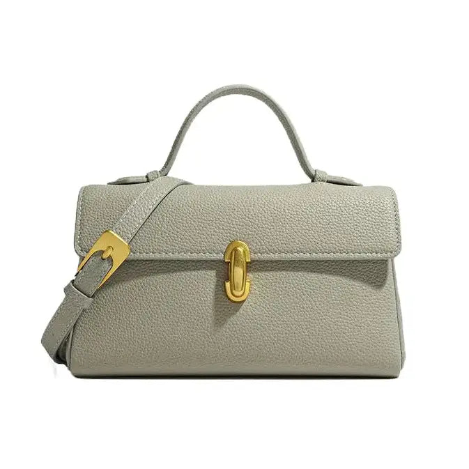 Gray handbag with gold hardware on a white background