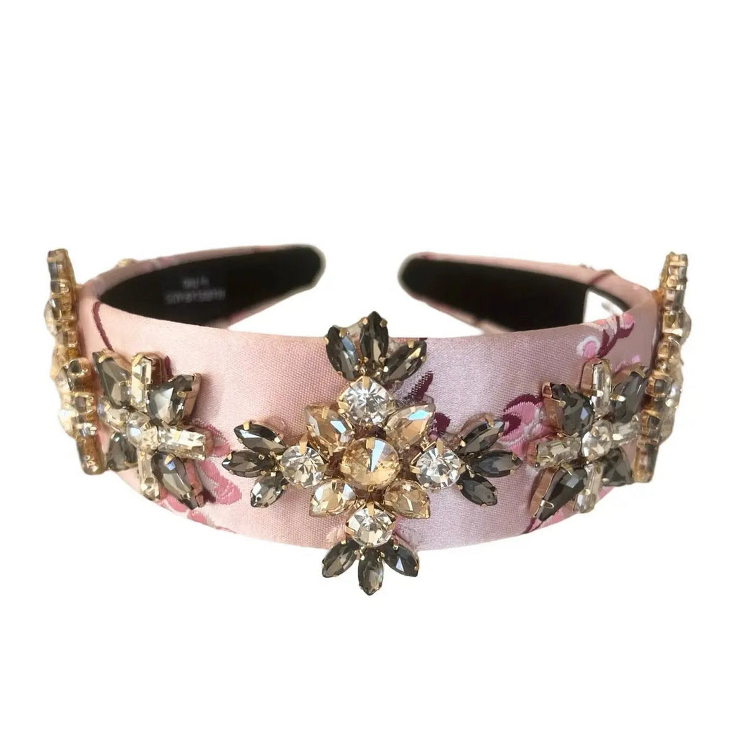 Decorative headband with floral and crystal embellishments on a white background