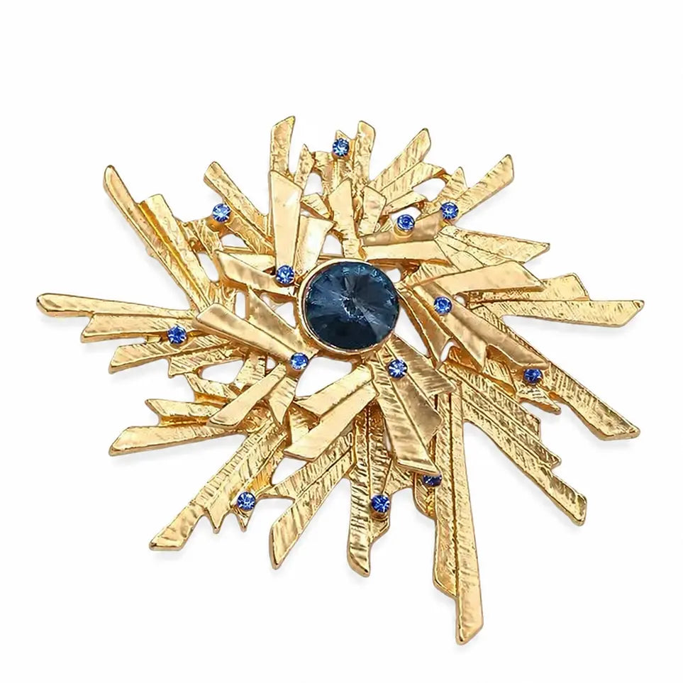 Gold star-shaped brooch with blue gemstones on a white background