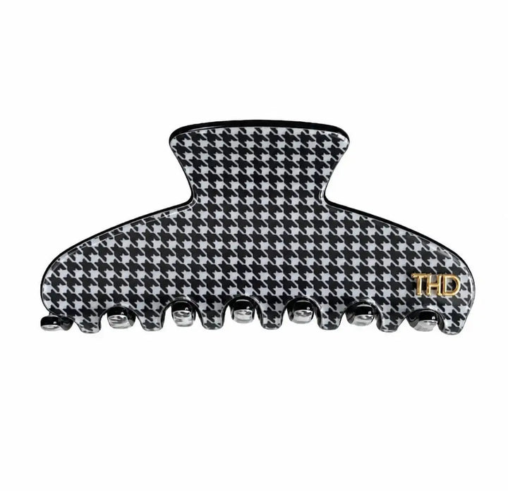 A black and white houndstooth hair claw clip with a small gold 'THD' logo on the right side, shown against a plain white background.
