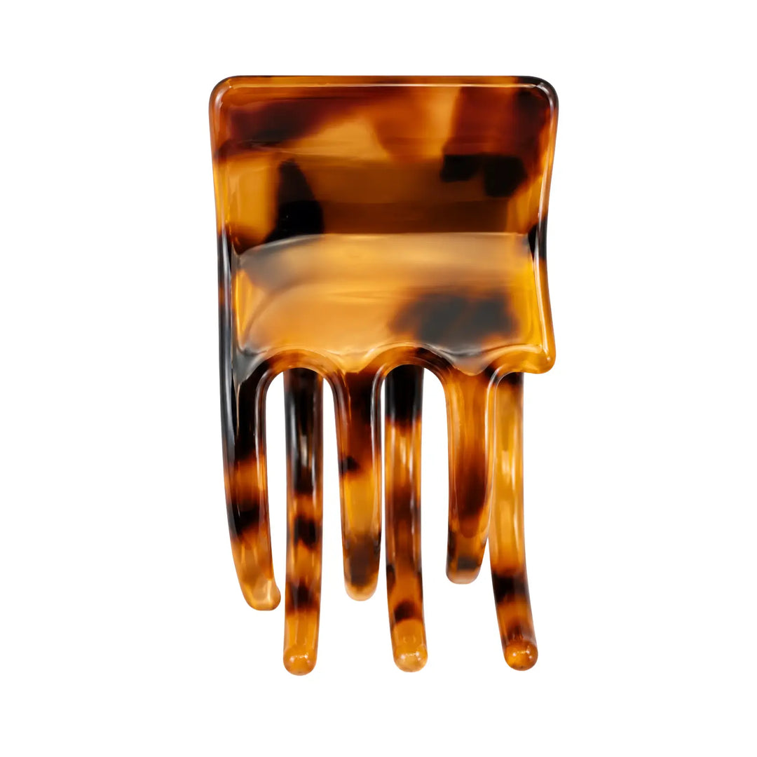 Tortoiseshell patterned hair comb on a white background