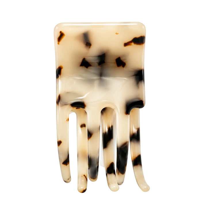 Tortoiseshell patterned hair comb on a white background