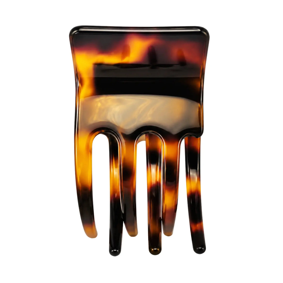 Tortoiseshell patterned hair comb on a white background
