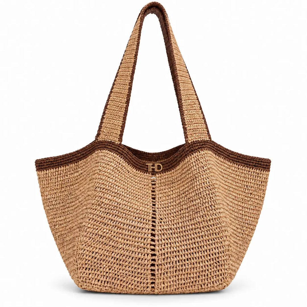 A natural woven Raffia tote bag with dark brown trim and handles, featuring a small gold 'THD' logo on the front.