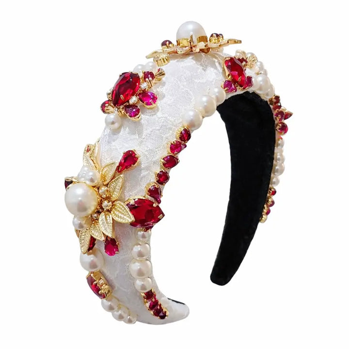 Decorative headband with pearls, red gemstones, and gold accents on a white background